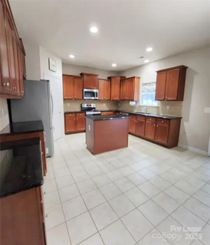 a kitchen with stainless steel appliances granite countertop a stove top oven a sink a counter top space and cabinets