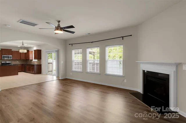 a view of an empty room with a fireplace and a window