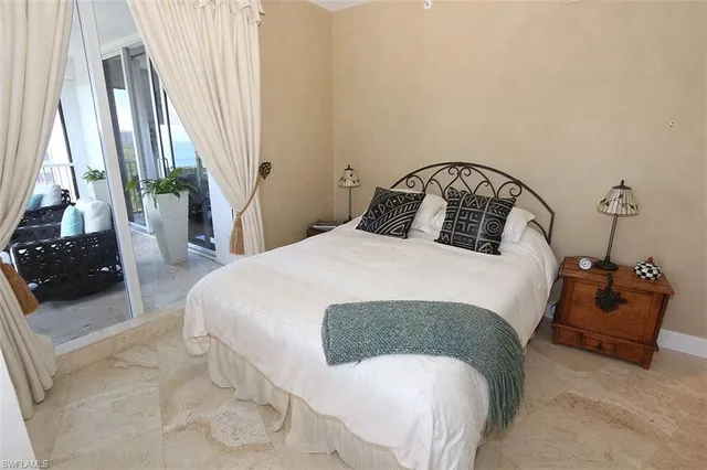 a bedroom with a bed and a large window