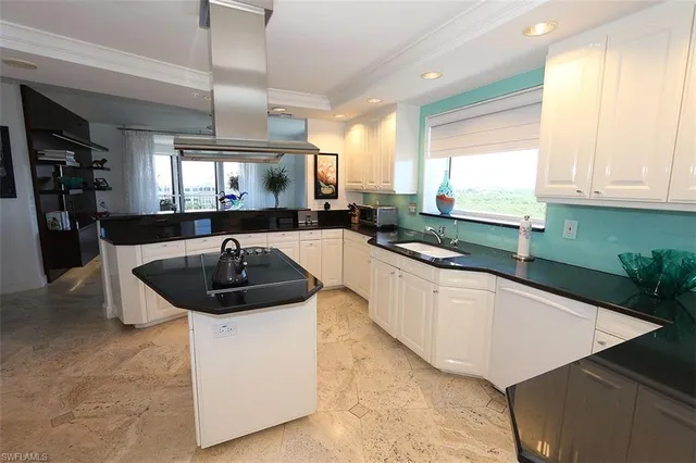 a kitchen with sink a window and chairs