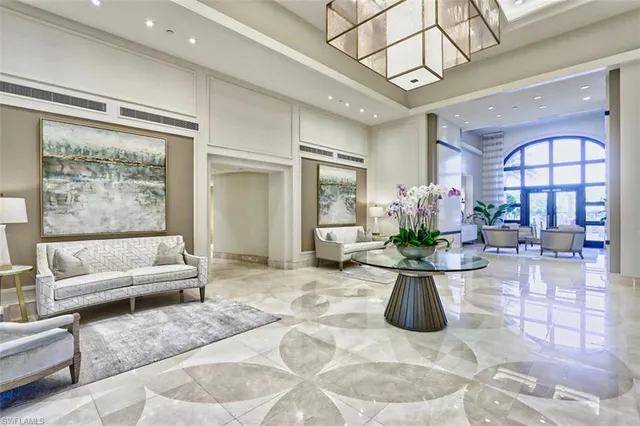 a living room with furniture a fireplace and a chandelier