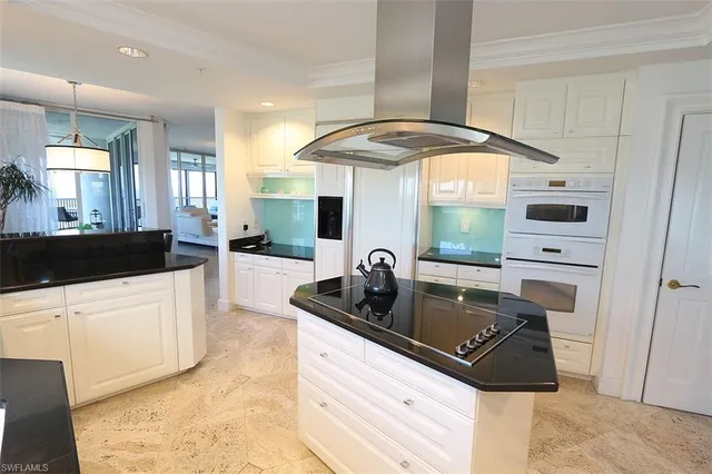 a kitchen with a sink a stove and white cabinets