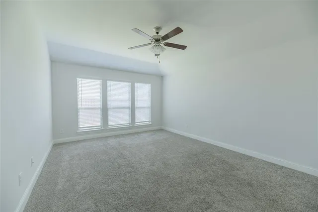 an empty room with a window and a ceiling fan