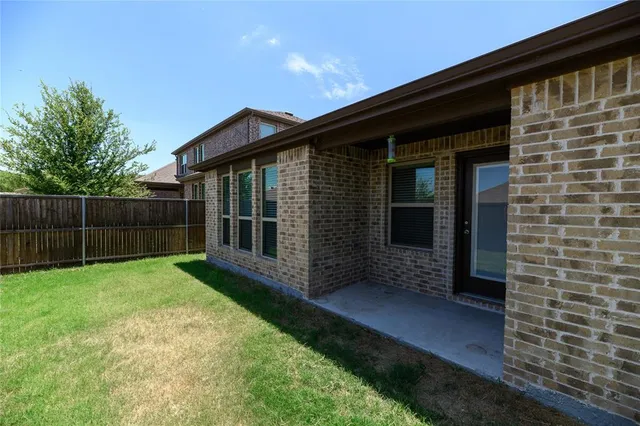a view of a house with a yard and wooden fence