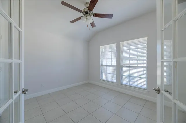 an empty room with windows and fan