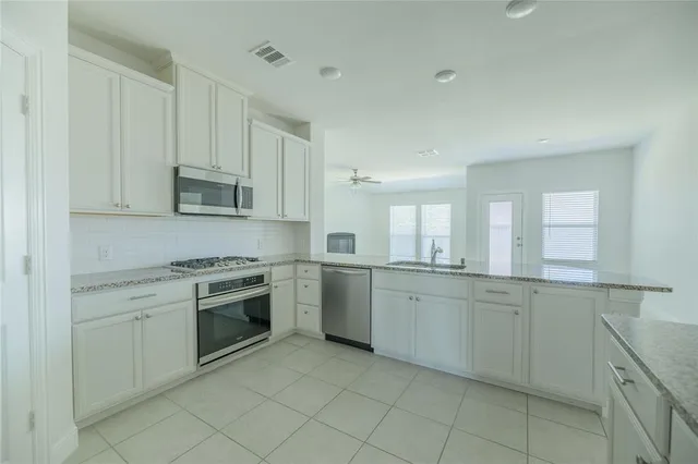 a kitchen with sink cabinets and appliances