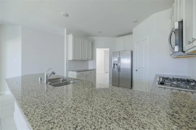 a kitchen with granite countertop a sink and a refrigerator