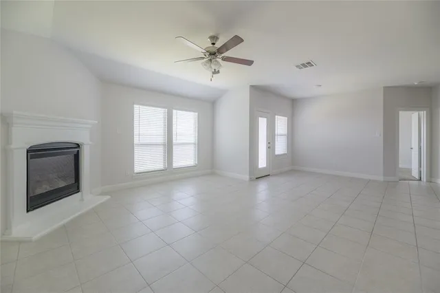 a view of an empty room with a fireplace and a window