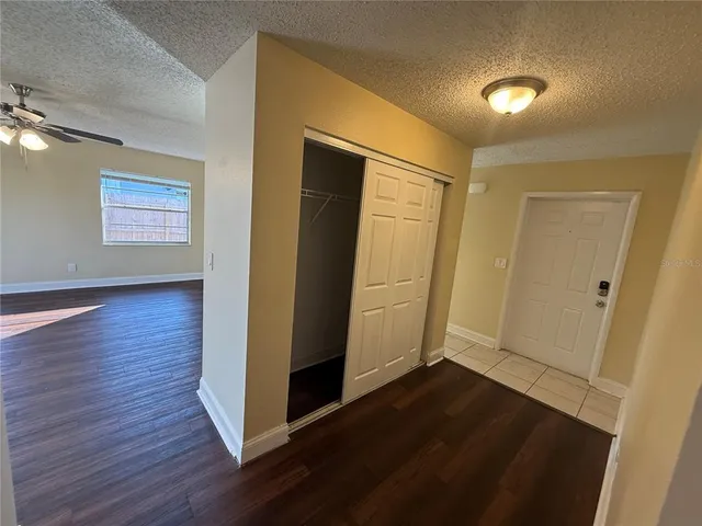 an empty room with wooden floor and window