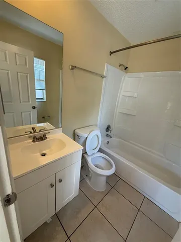 a bathroom with a sink a toilet a mirror a bathtub and shower