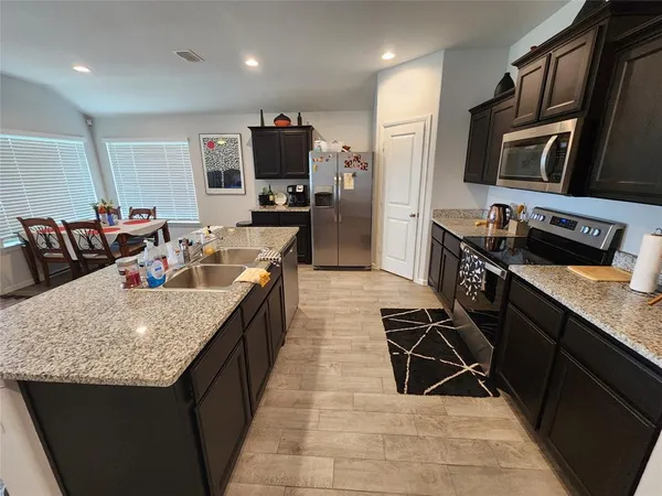 a kitchen with stainless steel appliances granite countertop a sink stove and refrigerator