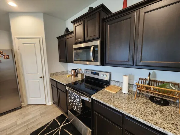 a kitchen with granite countertop a sink and a stove top oven