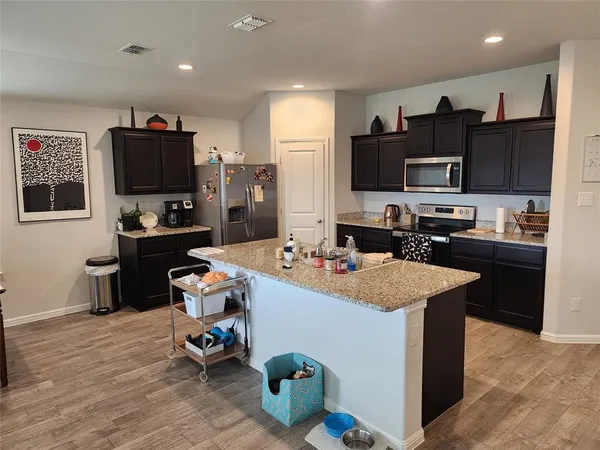 a kitchen with kitchen island a sink stove and refrigerator