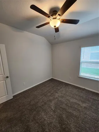 an empty room with a window and a fan