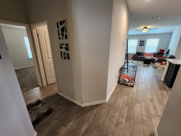 a view of a hallway with furniture and wooden floor
