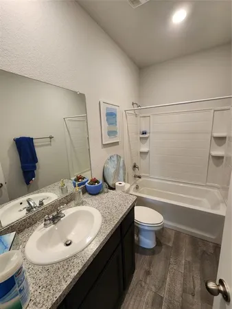 a bathroom with a granite countertop sink toilet and shower