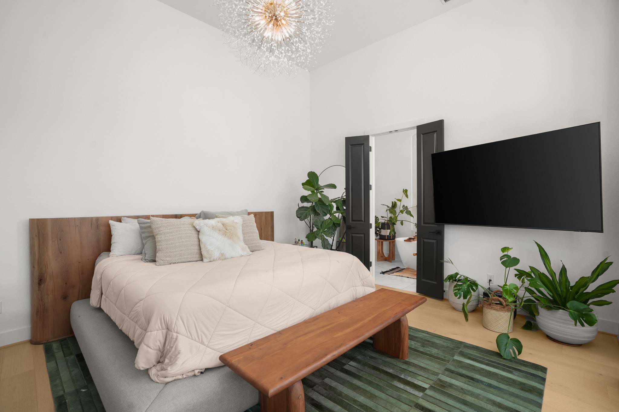 154 LITTLE Strm Cove Austin, TX 78737 - Photo 13 of 37 Gleaming hardwood floors and a striking chandelier define this light-filled modern bedroom.