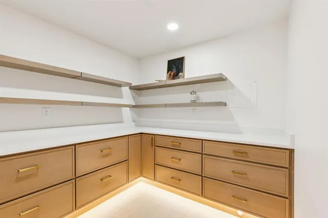 a large white kitchen with a stove a sink a refrigerator and a refrigerator