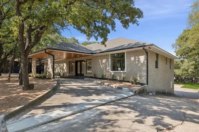 a front view of a house with a tree