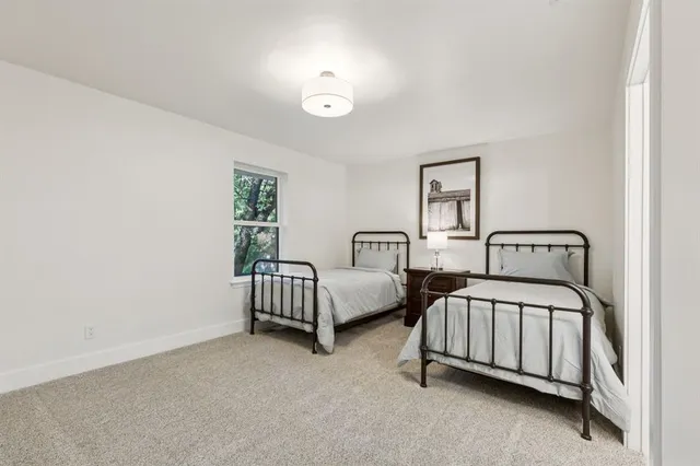 a bedroom with two beds and a window