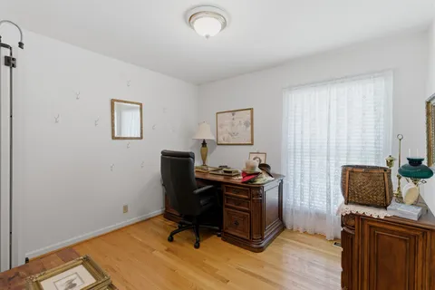 a view of a workspace with furniture and a window
