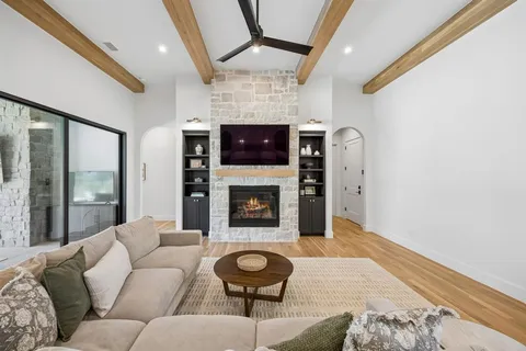 a living room with furniture a flat screen tv and a fireplace