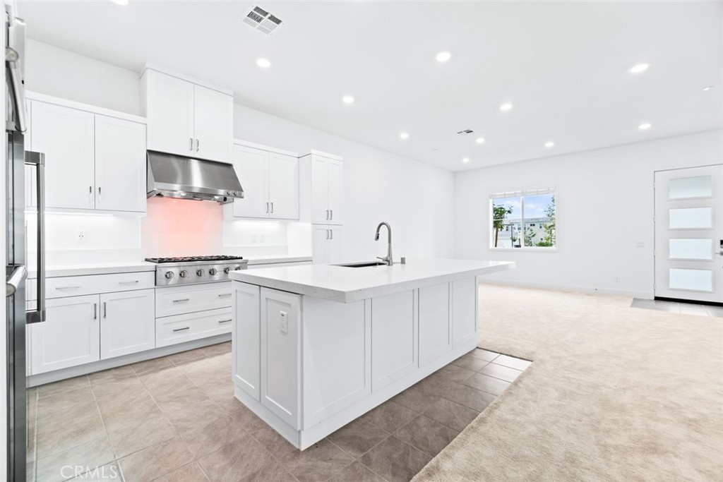 374 Baluster Irvine, CA 92618 - Photo 12 of 64 a kitchen with white cabinets and stainless steel appliances