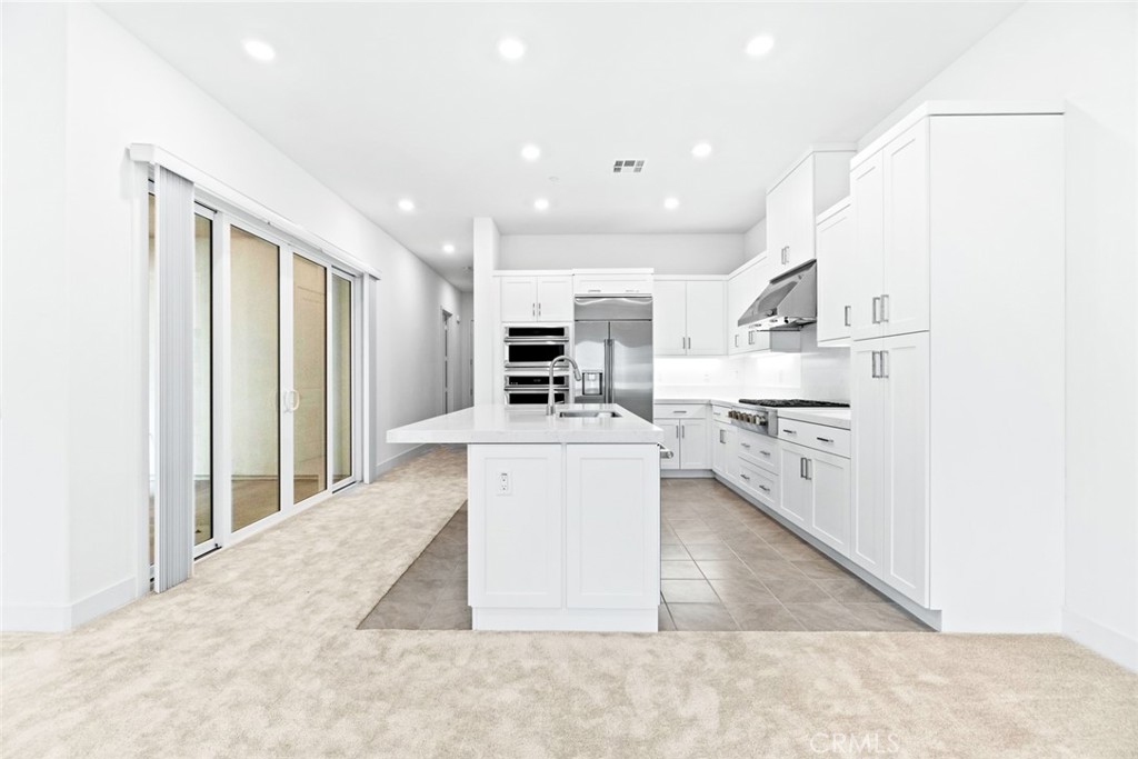 374 Baluster Irvine, CA 92618 - Photo 6 of 64 a large white kitchen with kitchen island a sink a stove and a refrigerator