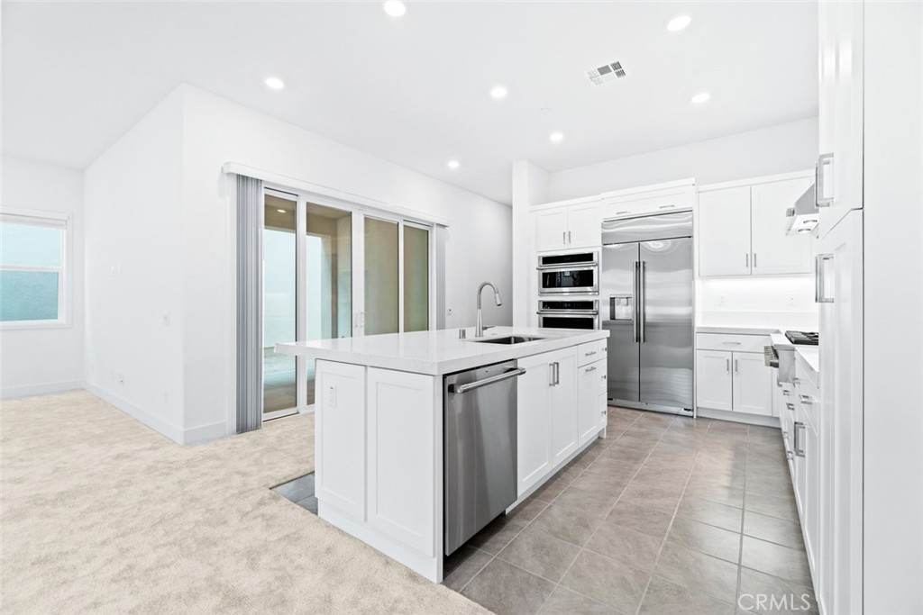 374 Baluster Irvine, CA 92618 - Photo 9 of 64 a kitchen with white cabinets and stainless steel appliances