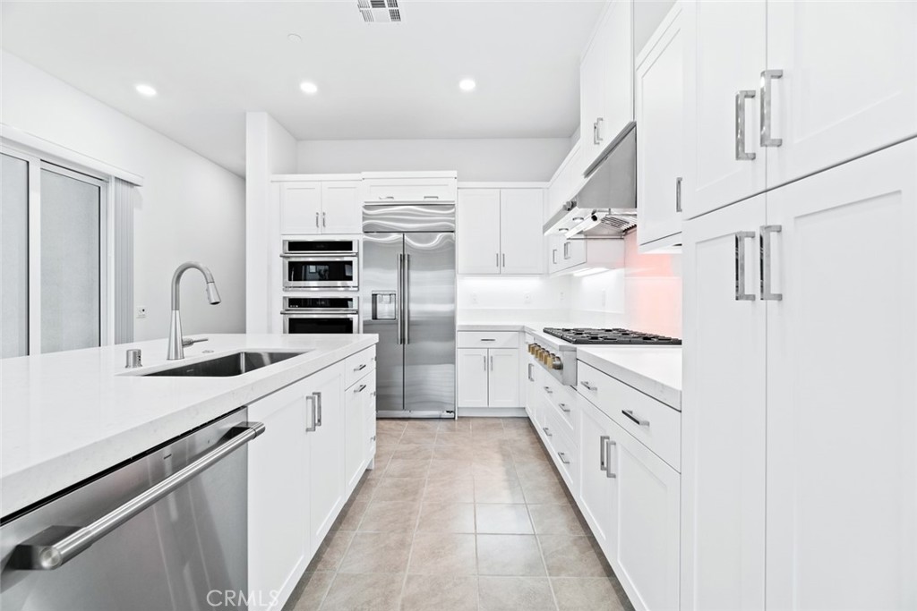 374 Baluster Irvine, CA 92618 - Photo 10 of 64 a large kitchen with stainless steel appliances a sink and cabinets