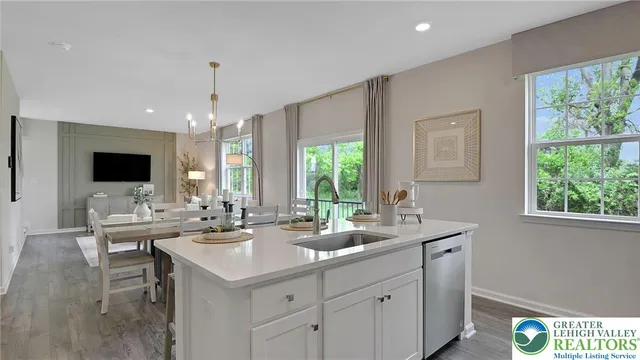 a view of a kitchen with kitchen island a sink stainless steel appliances and living room view