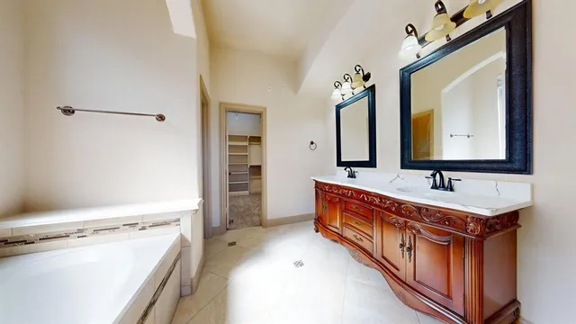 a bathroom with a tub sink and mirror