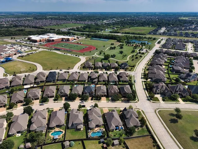 an aerial view of a city with lots of residential buildings and parking space