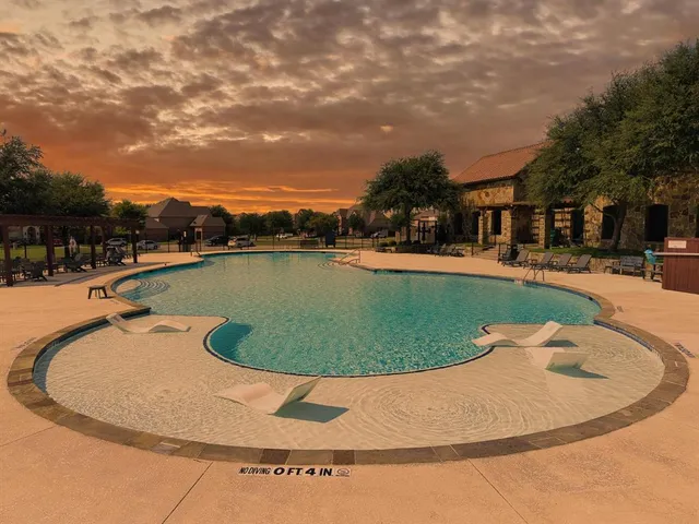 a view of a swimming pool with an outdoor seating and a garden view