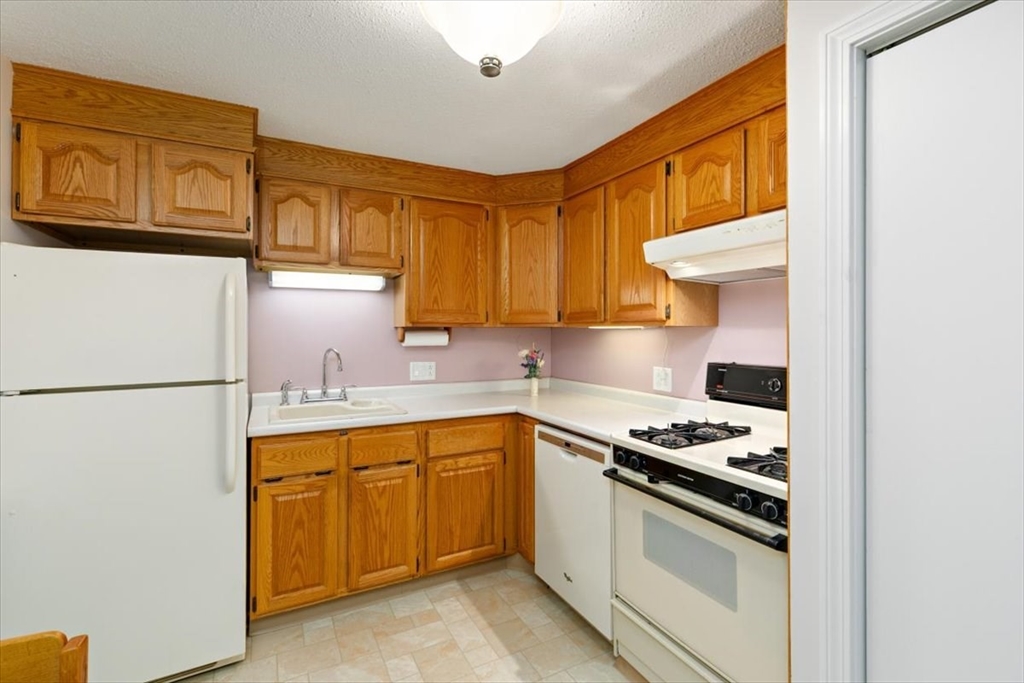 42 Main Street, Unit 22 North Reading, MA 01864 - Photo 16 of 37 a kitchen with granite countertop a sink a stove and refrigerator