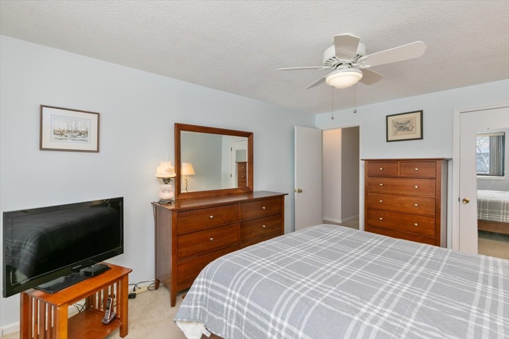 42 Main Street, Unit 22 North Reading, MA 01864 - Photo 21 of 37 a bedroom with a bed and a flat screen tv