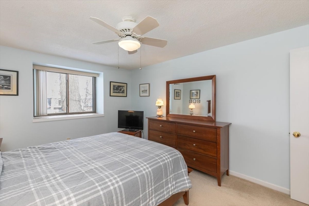 42 Main Street, Unit 22 North Reading, MA 01864 - Photo 22 of 37 a bedroom with a bed and a chandelier