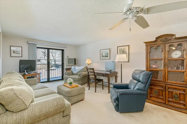 a living room with furniture ceiling fan and a window