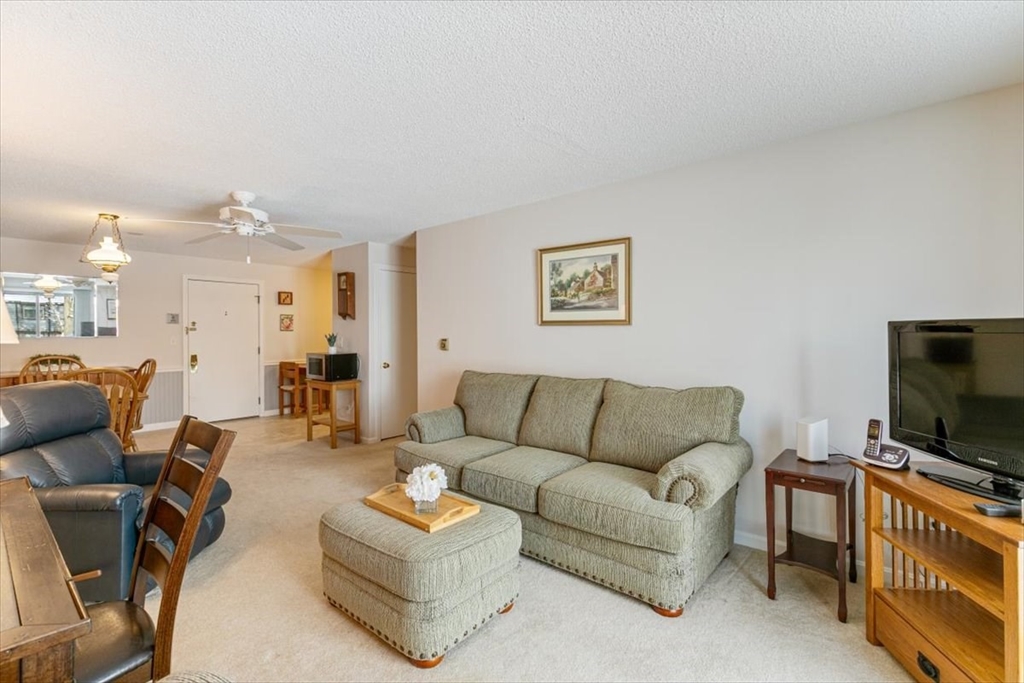 42 Main Street, Unit 22 North Reading, MA 01864 - Photo 10 of 37 a living room with furniture and a flat screen tv