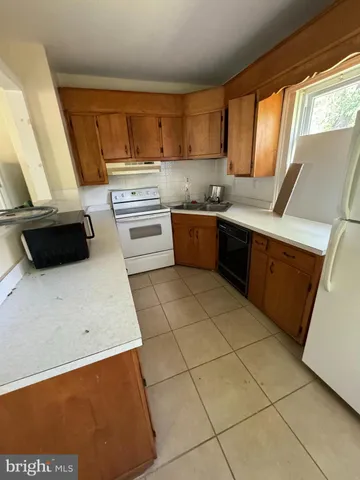a kitchen with a sink a stove top oven a counter space and cabinets
