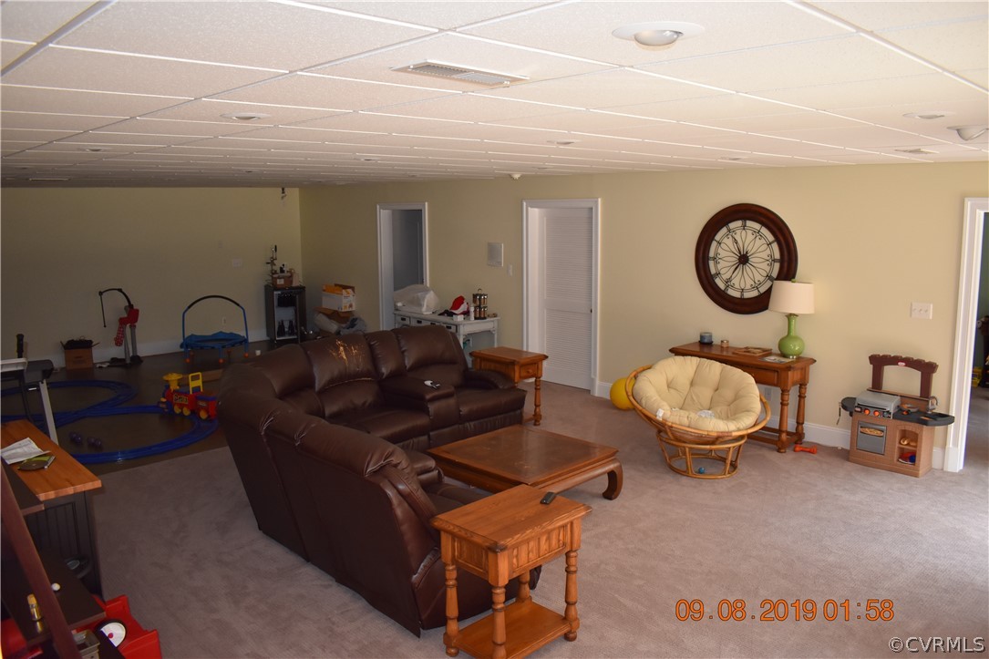 872 Wilson Road Wilsons, VA 23894 - Photo 27 of 34 a living room with furniture a clock and a large window