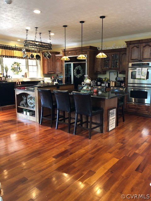 872 Wilson Road Wilsons, VA 23894 - Photo 7 of 34 a view of a kitchen with stainless steel appliances granite countertop a stove a refrigerator a dining table and chairs with wooden floor