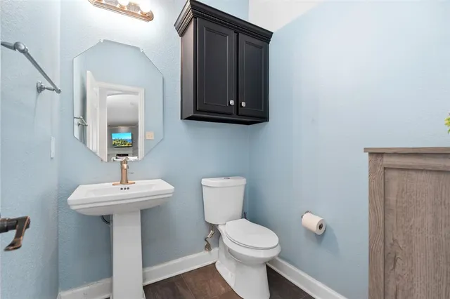 a bathroom with a toilet sink and mirror