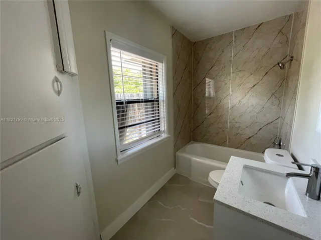 a bathroom with a bathtub a sink and a window