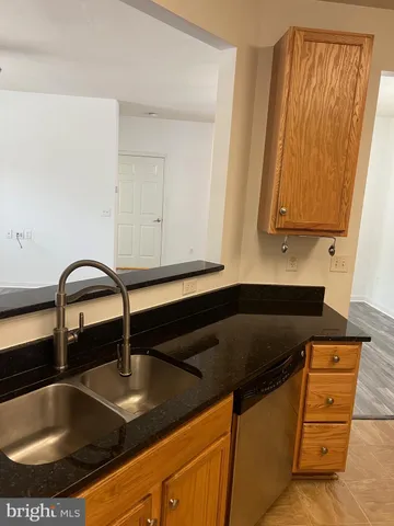a kitchen with granite countertop a sink and cabinets