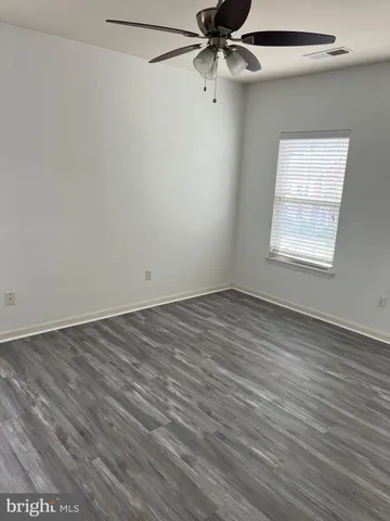 an empty room with a window and a ceiling fan