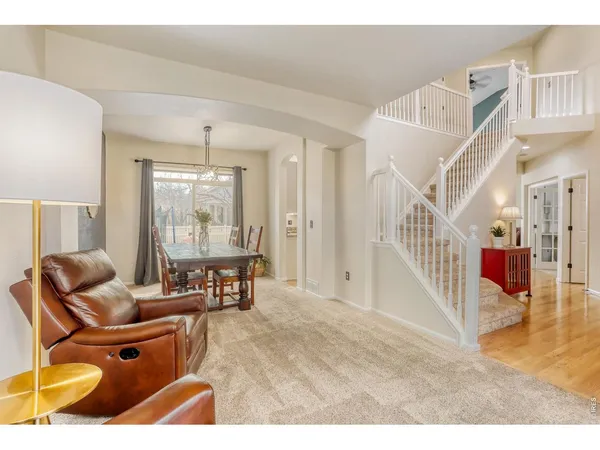 a kitchen with stainless steel appliances granite countertop a refrigerator a stove a sink and a white cabinets with wooden floor