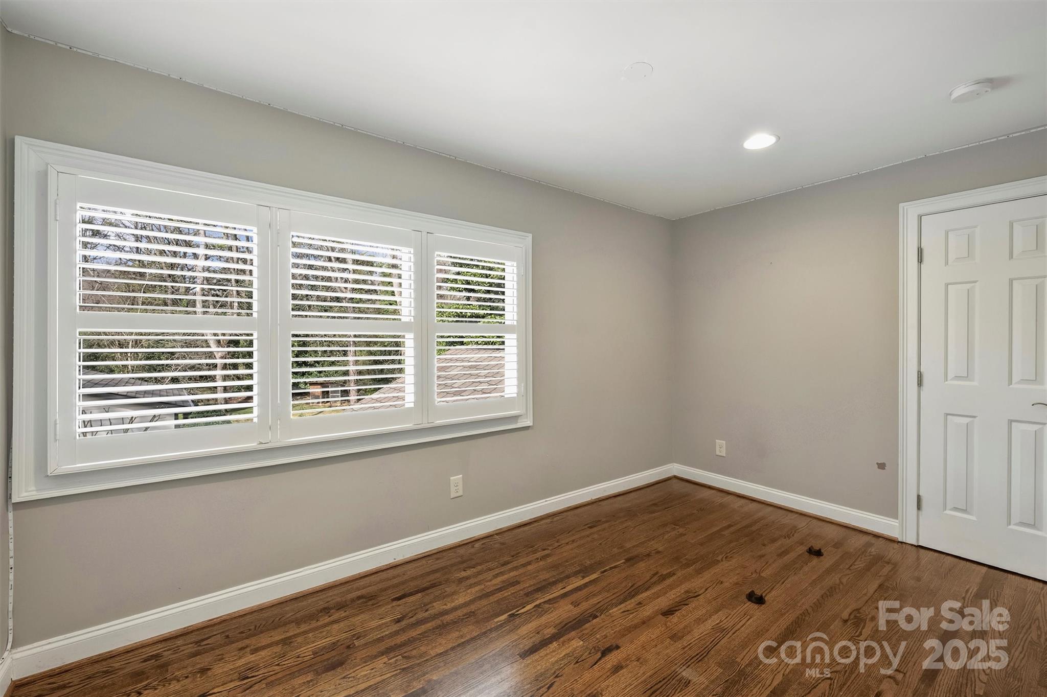 830 Jefferson Drive Charlotte, NC 28270 - Photo 21 of 38 a view of an empty room with wooden floor and a window