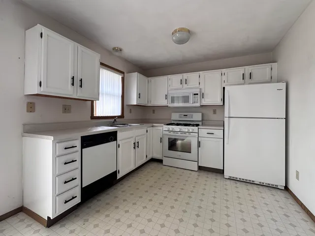 a kitchen with cabinets stainless steel appliances and sink