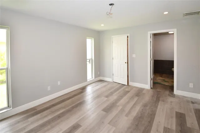 an empty room with windows and closet